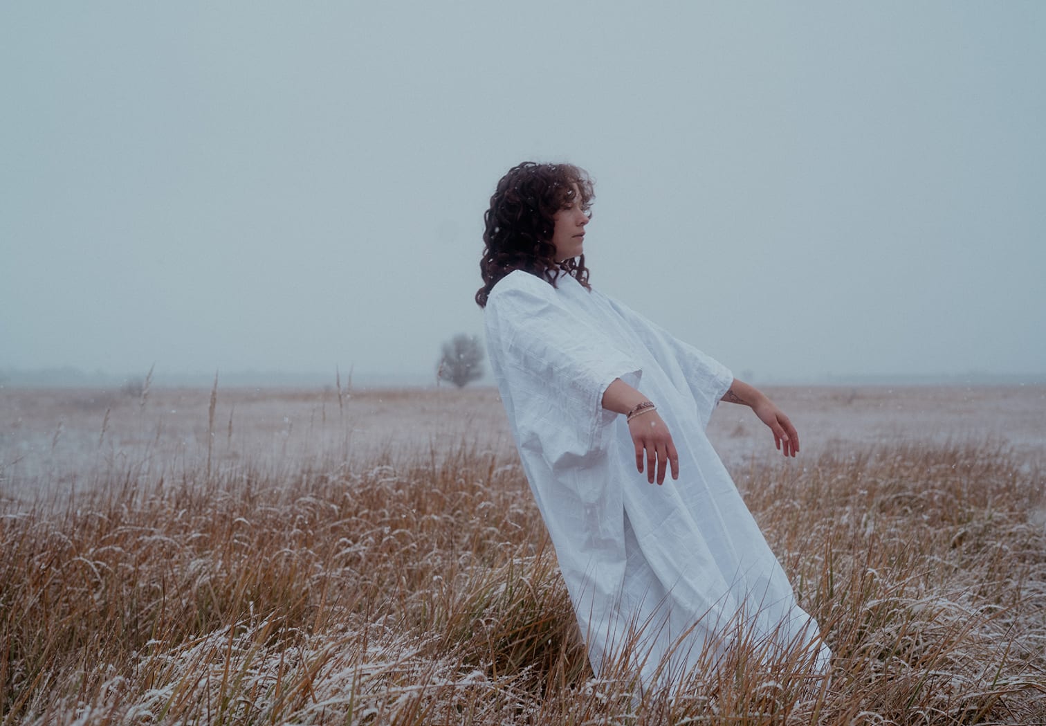 Person in a white robe on a frosty field